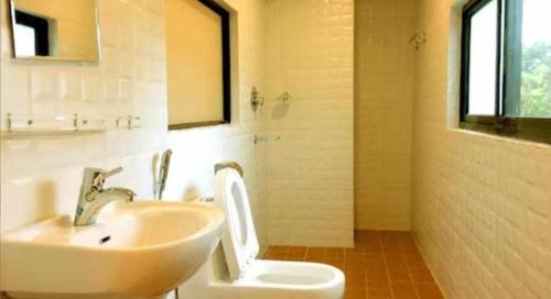 ein Bad mit einem Waschbecken und einem WC in der Unterkunft Hotel Suite Inn Lodge in Pokhara