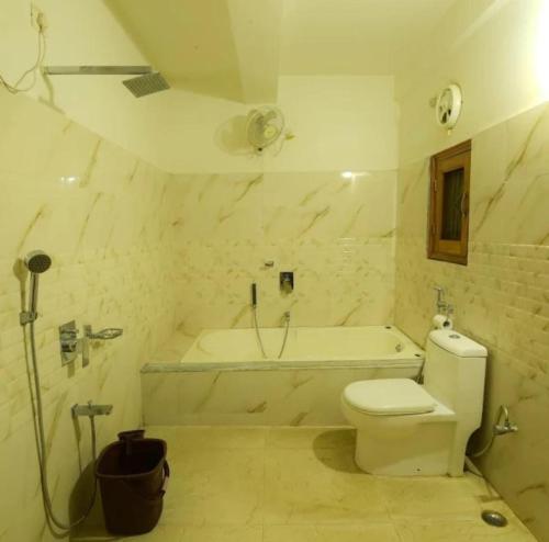 a bathroom with a toilet and a tub and a sink at Cozy Nest Homestay in Guwahati