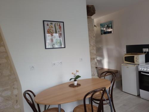 une petite cuisine avec une table et des chaises en bois dans l'établissement L'Escale, à Cormeilles