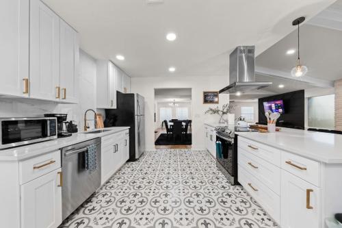 a kitchen with white cabinets and a tile floor at Spacious 6 Bed House near Airport, Pet-Friendly, Close to AFB in San Antonio