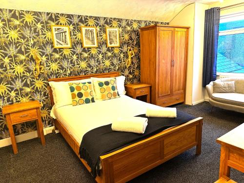 a bedroom with a bed and a chair in it at The Golden Fleece Inn in Porthmadog