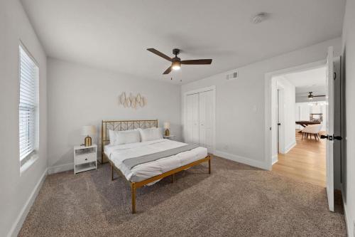 a white bedroom with a bed and a ceiling fan at Spacious 6 Bed House near Airport, Pet-Friendly, Close to AFB in San Antonio