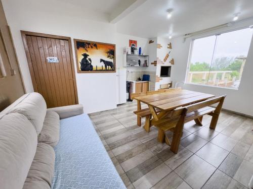 ein Wohnzimmer mit einem Holztisch und einem Sofa in der Unterkunft Bella Praia apartamento Girassol in Passo de Torres