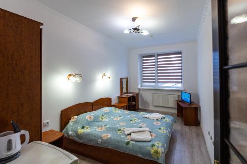 una camera da letto con un letto con una coperta blu e una finestra di Алексік a Truskavec'