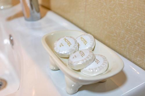 três rolos de papel higiénico numa tigela branca num lavatório em LILEO Hotel em Kutaisi