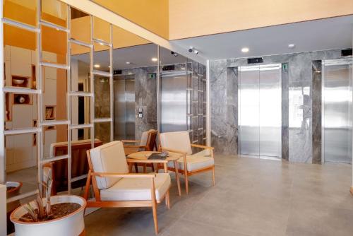 a room with chairs and a table and a glass wall at Krem Marin Suites Otel in Cesme