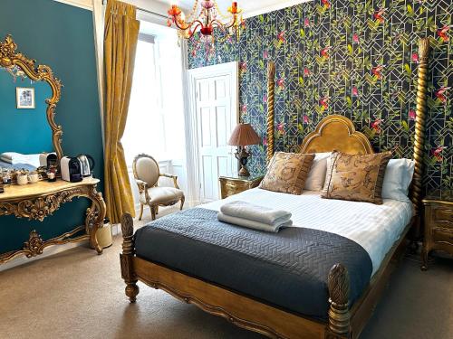 1 dormitorio con 1 cama con paredes azules y papel pintado con motivos florales en The Golden Fleece Inn en Porthmadog