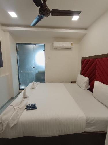 a large white bed with a remote control on it at AR Residency in Mumbai