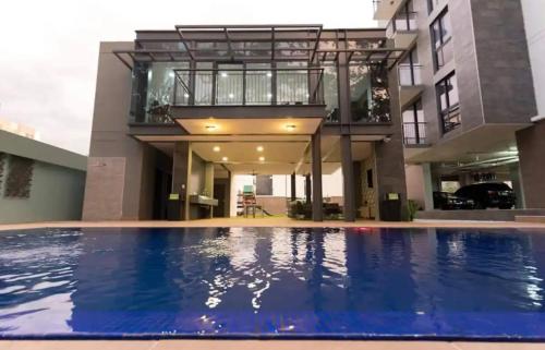 a house with a swimming pool in front of a building at Stylish Condo In Tribeca in San Pedro Sula