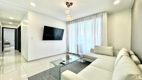 a living room with a white couch and a glass table at Stylish Condo In Tribeca in San Pedro Sula