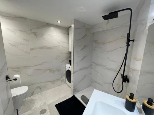 ein Badezimmer mit einem weißen Waschbecken und einer Dusche in der Unterkunft Altea Beach Apartment in Altea