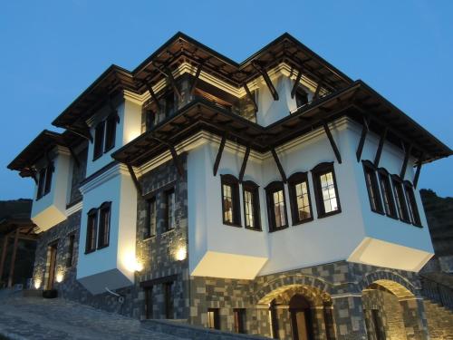 a large white building with a gambrel roof at Pupa Winery Serene Stay in Berat