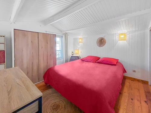 une chambre avec un grand lit rouge avec des oreillers rouges dans l'établissement Porte du Vignoble Séjour à Libourne, à Libourne