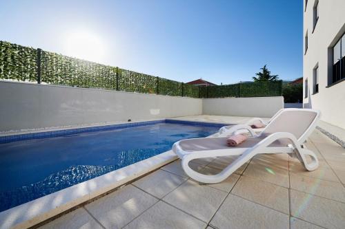 a baby laying on a chaise lounge next to a swimming pool at Sore in Trogir