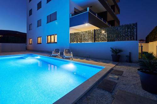 a swimming pool in front of a building at night at Sore in Trogir