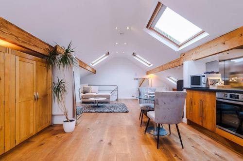 a kitchen and living room with a table and chairs at The Loft Suite - Cheadle in Cheadle Hulme