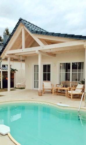 a pavilion with a swimming pool in front of a house at Mabé in Lauta
