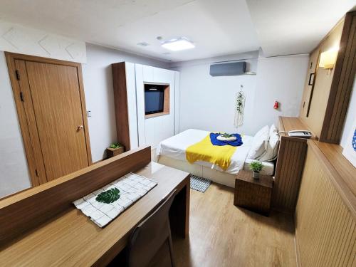 Cette petite chambre comprend un lit et un bureau. dans l'établissement Residence Yeoyu, à Guri