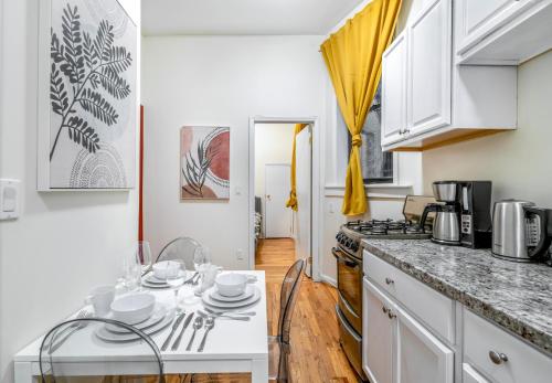 ニューヨークにあるCozy 2BD Stylish Home for Rentのキッチン(白いキャビネット、白いカウンタートップ付)