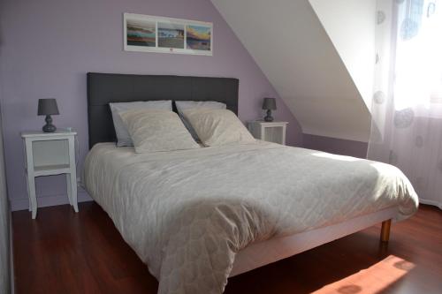 ein Schlafzimmer mit einem großen Bett mit zwei Nachttischen in der Unterkunft L' ESCALE SINAGOTE Chambre d'hôtes in Séné