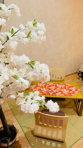 une table avec deux pizzas et un arbre avec des fleurs blanches dans l'établissement Little Japan, à Roubaix