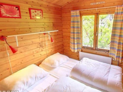 a bedroom with two beds in a log cabin at Geniet van het leven.. in De boomklever in Diffelen