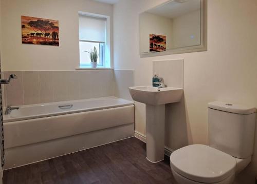 a bathroom with a sink and a tub and a toilet at Lovely 2 Bed, detached home. in Seacroft