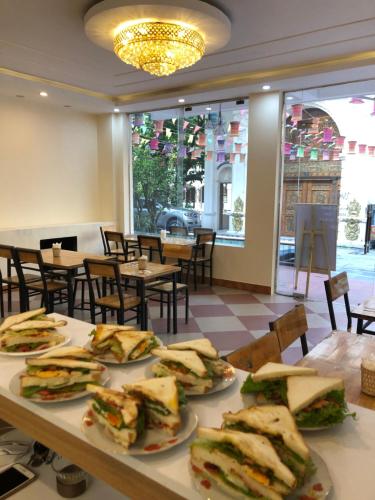 a table with plates of sandwiches on it in a restaurant at FIRONA FLY HOTEL in Sa Pa