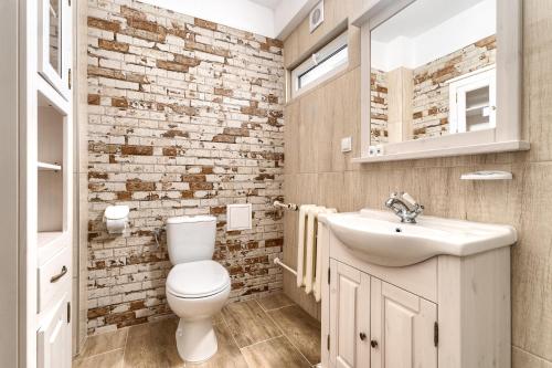 uma casa de banho com um WC branco e um lavatório. em Hotel Bocianie Gniazdo em Niechorze