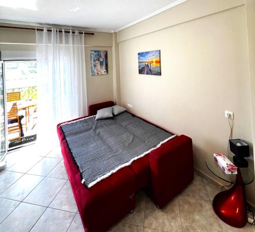 a bedroom with a red bed in a room at Seaside Apartment Aliki in Kallithea Halkidikis