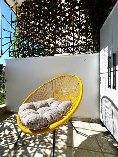 a yellow chair with a pillow on a patio at Seaside Apartment Aliki in Kallithea Halkidikis