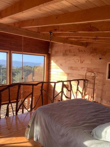 a bedroom with a bed and a large window at Cabaña con hermosa vista in Ancud