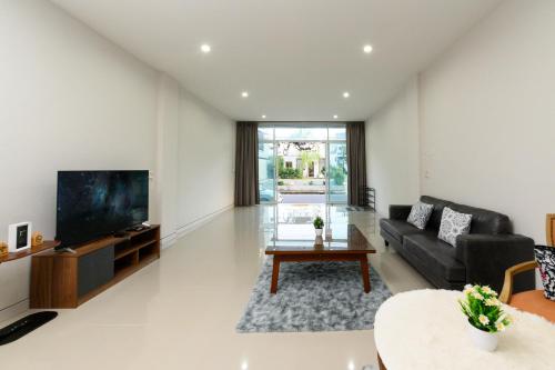 a living room with a couch and a tv at Calla House Hatyai for 18pax in Prime location 6 mins drive to Lee Grd in Hat Yai