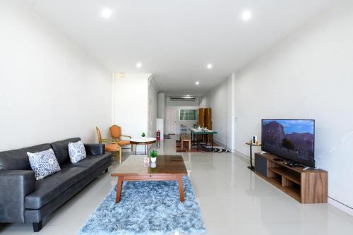 a living room with a couch and a tv at Calla House Hatyai for 18pax in Prime location 6 mins drive to Lee Grd in Hat Yai