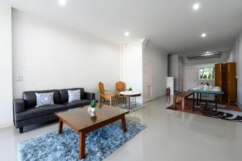 a living room with a couch and a table at Calla House Hatyai for 18pax in Prime location 6 mins drive to Lee Grd in Hat Yai