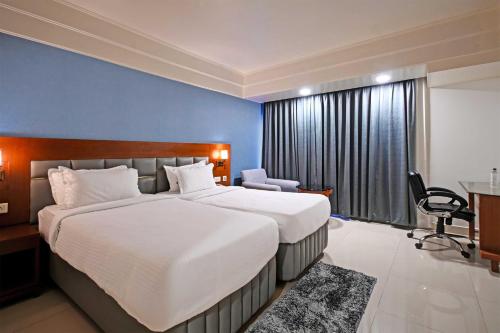 a hotel room with a large bed and a desk at Palette - Madhapur in Hyderabad