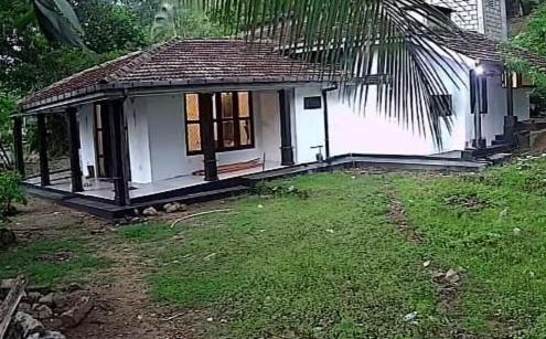 uma pequena casa com um jardim de relva em frente em Bracedale Estate em Kegalle