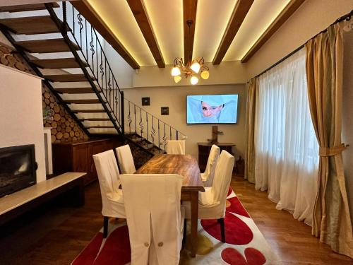 錫比烏的住宿－Real home 1，一间带桌椅和电视的用餐室