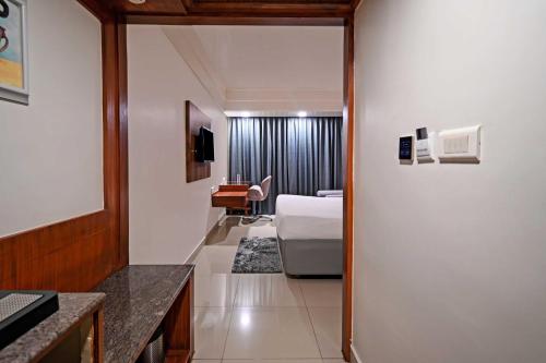 a hotel room with a bed and a desk at Palette - Madhapur in Hyderabad
