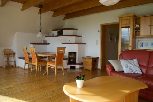 a living room with a red couch and a table at Idyllische Ferienwohnung in Seefeld in Norderaussendeich