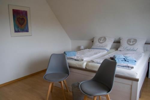 Habitación pequeña con 2 sillas y 1 cama en Idyllische Ferienwohnung in Seefeld, en Norderaussendeich