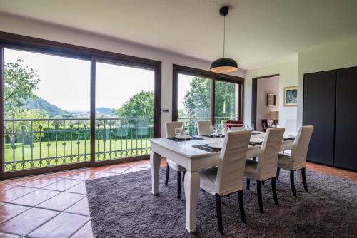 uma sala de jantar com uma mesa branca e cadeiras em Villa Tramonte em Teolo