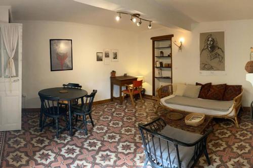 a living room with a bed and a table at Maisonnette de plain-pied plein cœur du perche in Igé