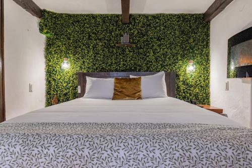 ein Schlafzimmer mit einem Bett mit einer grünen Wand in der Unterkunft Cozy Little Romm on Palace Patio in Sintra