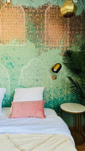 - un lit avec un oreiller rose dans l'établissement Évasion Emeraude, à Roubaix