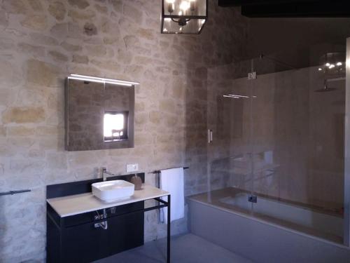 a bathroom with a sink and a tub and a mirror at Luxurious secluded villa in Calaceite
