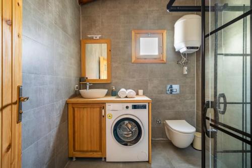 ein Badezimmer mit einer Waschmaschine und einem Waschbecken in der Unterkunft Karaincirevleri Müstakil Taş Ev in Emecik