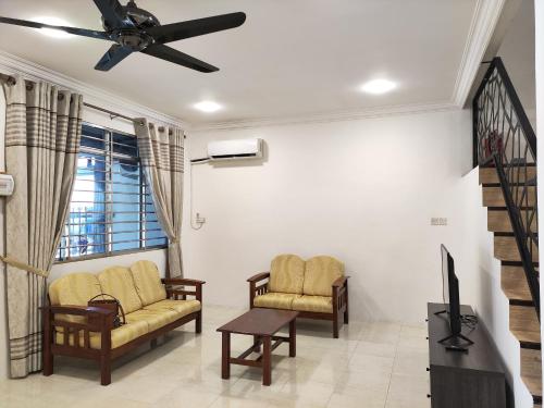 a living room with two chairs and a tv at Sibu T1 Homestay, 4 Bedrooms in Sibu