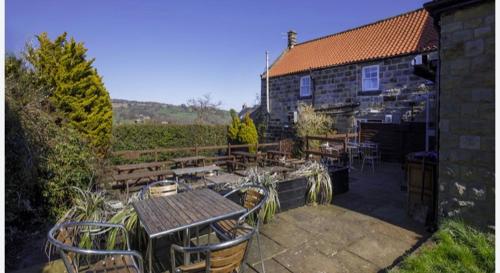 a patio with tables and chairs and a building at The Plough in Sleights