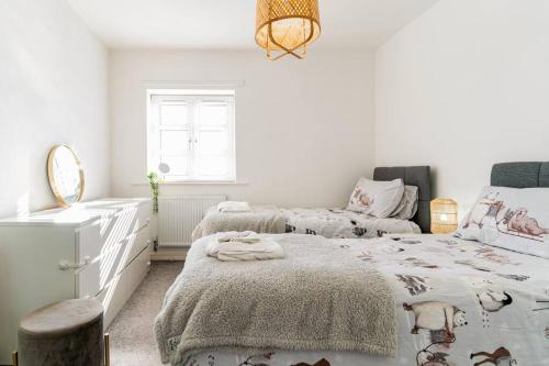 ein weißes Schlafzimmer mit 2 Betten und einem Spiegel in der Unterkunft Stunning Ground Floor Hartlepool Marina Apartment in Hartlepool